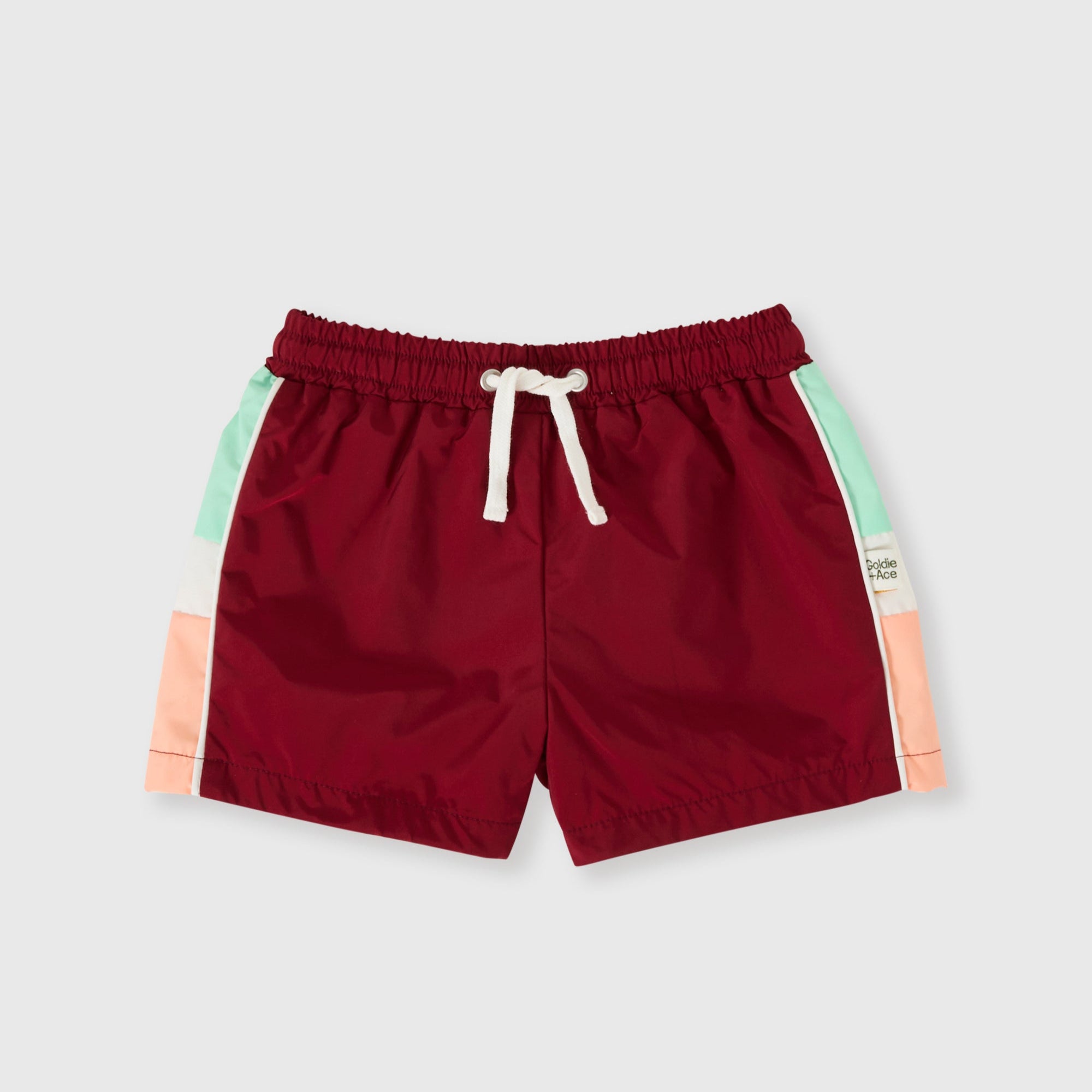 Red shorts with colorful side panels on a light gray background