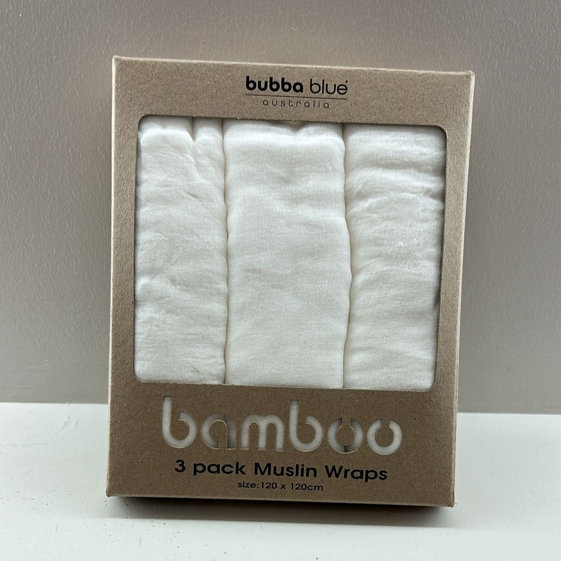 Pack of bubba blue bamboo muslin wraps on a white surface with a gray background